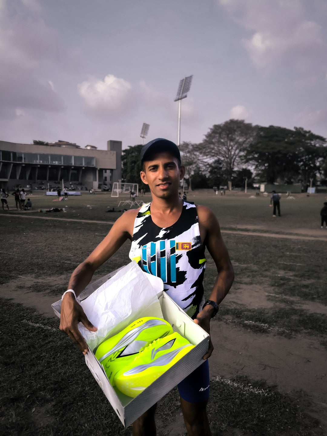 Udara Chanaka Rupasinghe holding his new Li-Ning racing shoes in their box on a Colombo training ground