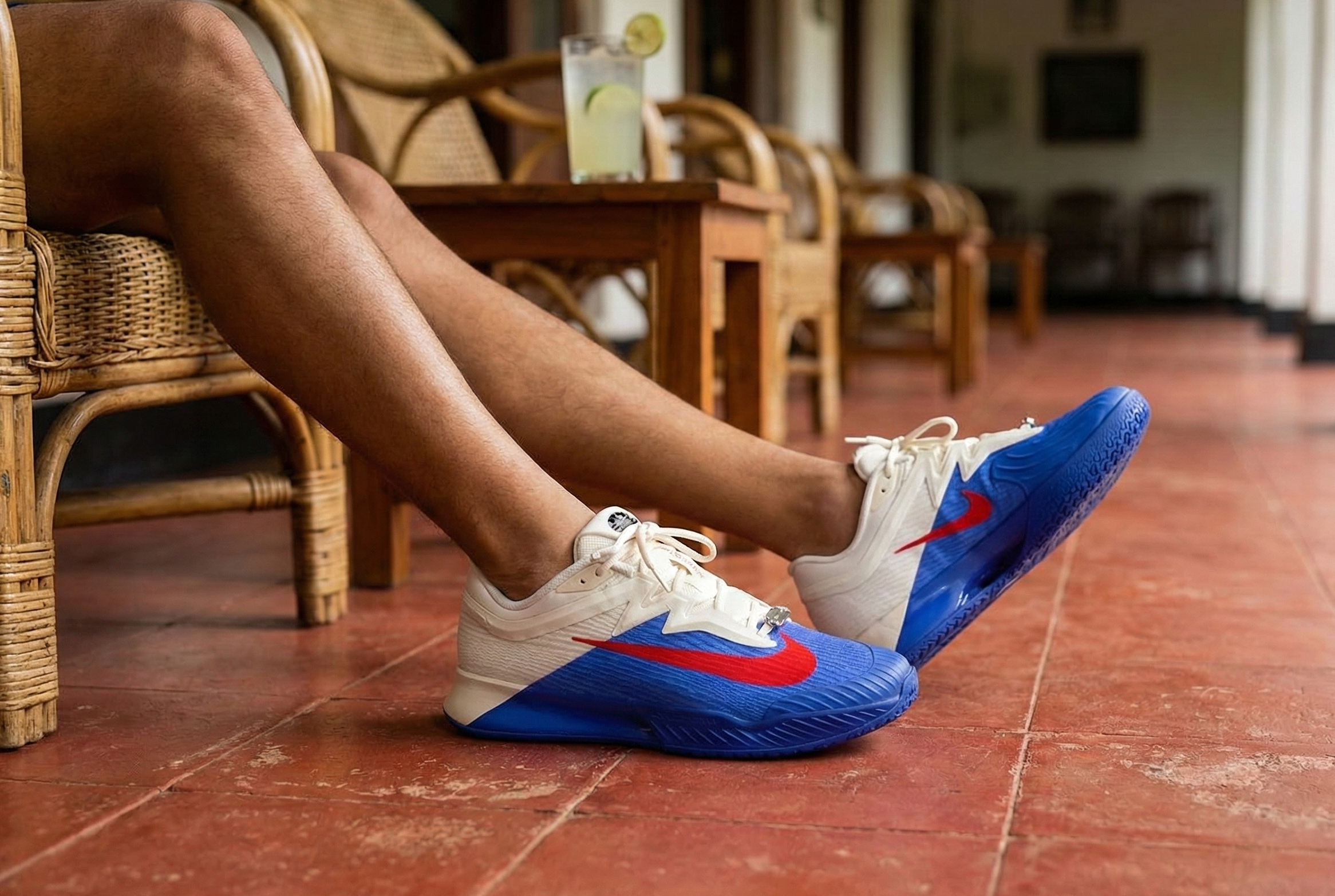 Person wearing Nike Vapor Pro 3 Premium sneakers with blue soles in a casual setting