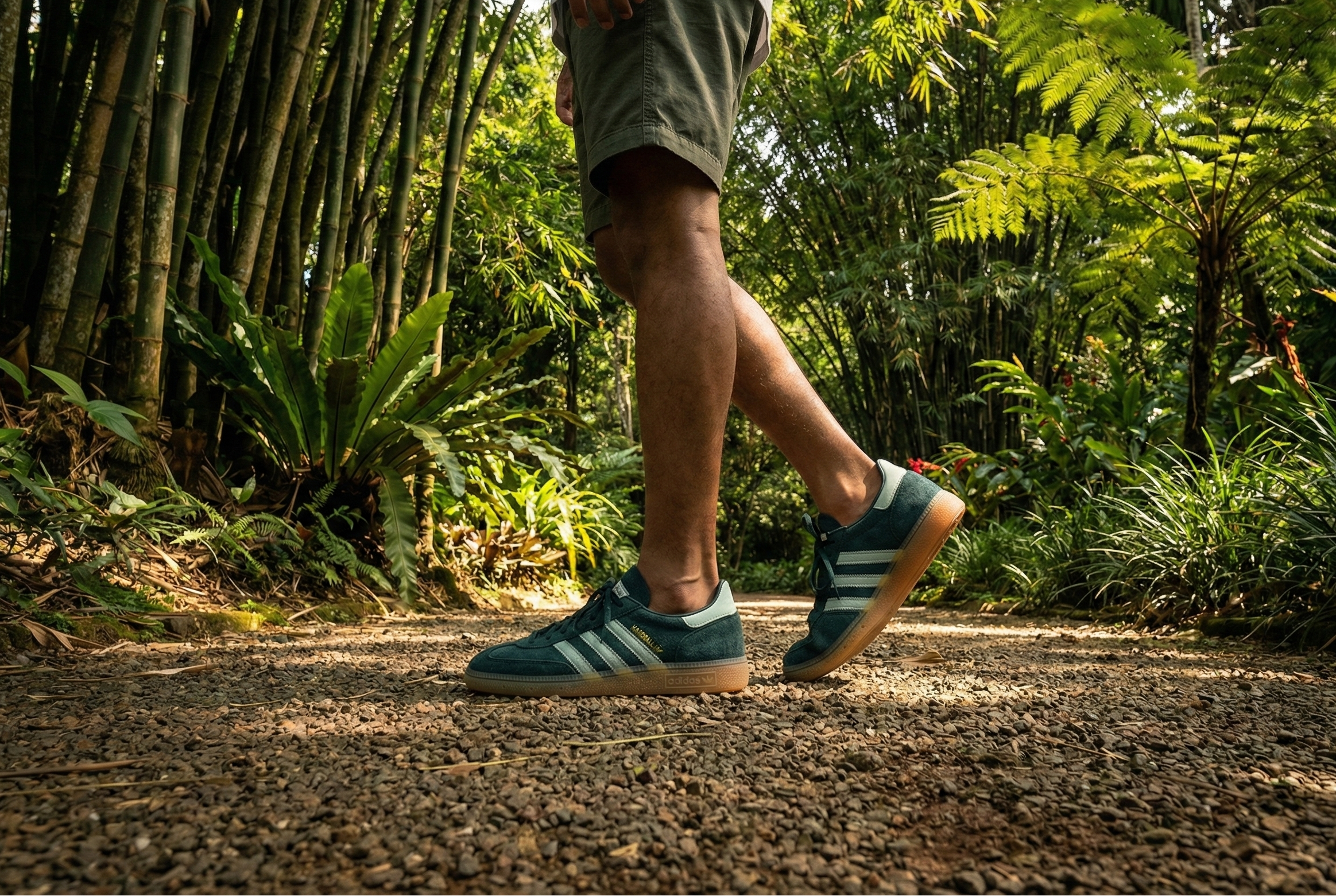 Person walking on a path in a forest wearing green Adidas Handball Spezial Shoes.