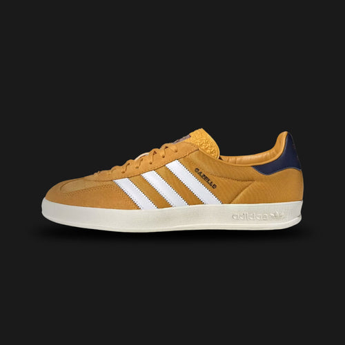adidas Gazelle Indoor shoes in Preloved Yellow, Cloud White, and Dark Blue (Design Code: IE0540). Featuring a premium suede upper in muted yellow, serrated leather three-stripes in white, and a dark blue leather heel tab. Includes the signature translucent gum rubber outsole that wraps around the midsole for a classic heritage look. Luxuntique offers 100% authentic adidas terrace sneakers at the lowest price in Sri Lanka.