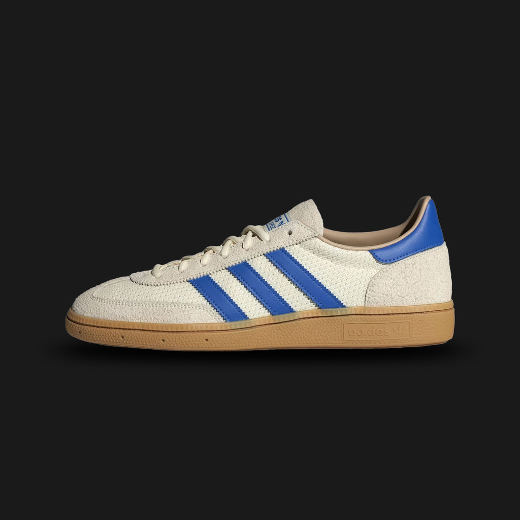 Adidas Handball Spezial shoes in Cream White, Blue, and Warm Sandstone (JS3865). Features a classic terrace silhouette with a premium Cream White suede upper and the signature T-toe overlay. Includes bold Blue 3-Stripes, Warm Sandstone accents, and a retro Gum rubber traction outsole. Luxuntique guarantees 100% authentic Adidas footwear in Sri Lanka.