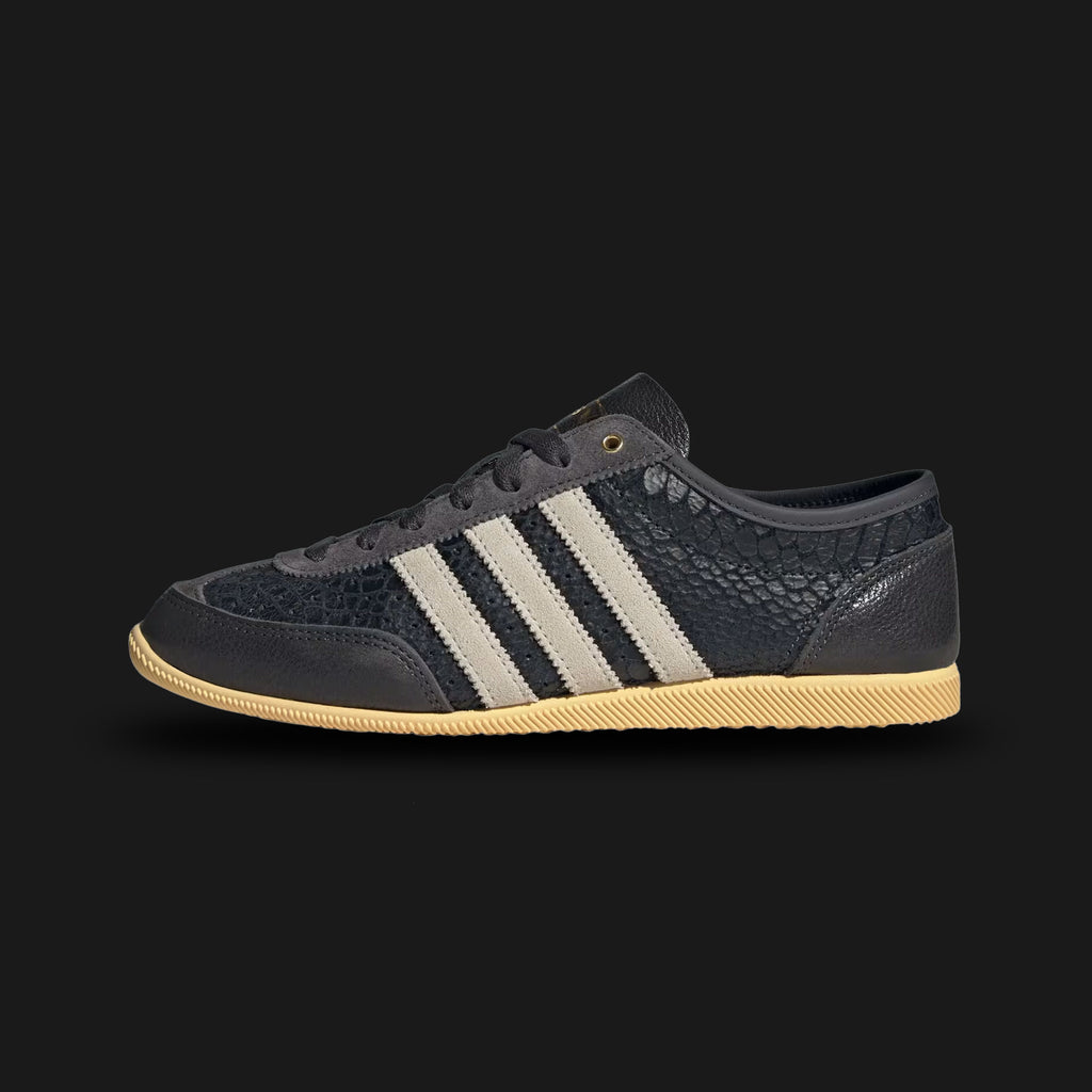 Adidas Japan Decon shoes in Utility Black, Cream White, and Orange Tint (IH1621). Features an ultra-soft deconstructed black leather upper with cream Three Stripes and subtle orange branding. Lightweight, flexible low-profile design with a thin rubber outsole. Luxuntique offers 100% authentic Adidas in Sri Lanka.