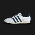 Adidas Japan vintage shoes in Cloud White, Collegiate Green, and Aurora Ivy (JQ9062). Features a sleek 1964 heritage low-profile silhouette with a premium Cloud White leather upper and a classic suede T-toe overlay. Includes crisp Collegiate Green and Aurora Ivy 3-Stripes, vintage branding, and a slim rubber traction outsole. Luxuntique guarantees 100% authentic Adidas footwear in Sri Lanka.