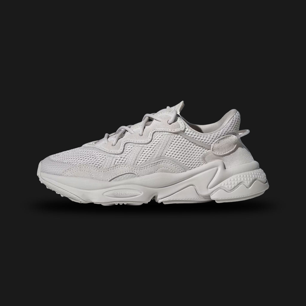 Adidas OZWEEGO shoes in Chalk Pearl and Cloud White (FY2023). Features a retro-futuristic layered upper with premium suede, mesh, and TPU overlays. Includes the signature translucent nylon support tube, Adiprene+ forefoot cushioning, and Adiprene heel cushioning in a chunky EVA midsole. Luxuntique offers 100% authentic Adidas in Sri Lanka.