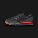 Adidas SL 72 RS Audi Revolut F1 Team shoes in Utility Black and Hi-Res Red (KJ1203). Features a premium reshaped leather and technical textile upper with vibrant red F1 racing accents. Includes collaborative Audi Revolut branding on the tongue and heel, a thickened EVA midsole for modern cushioning, and a signature ripple rubber outsole. Luxuntique offers 100% authentic Adidas F1 gear in Sri Lanka.