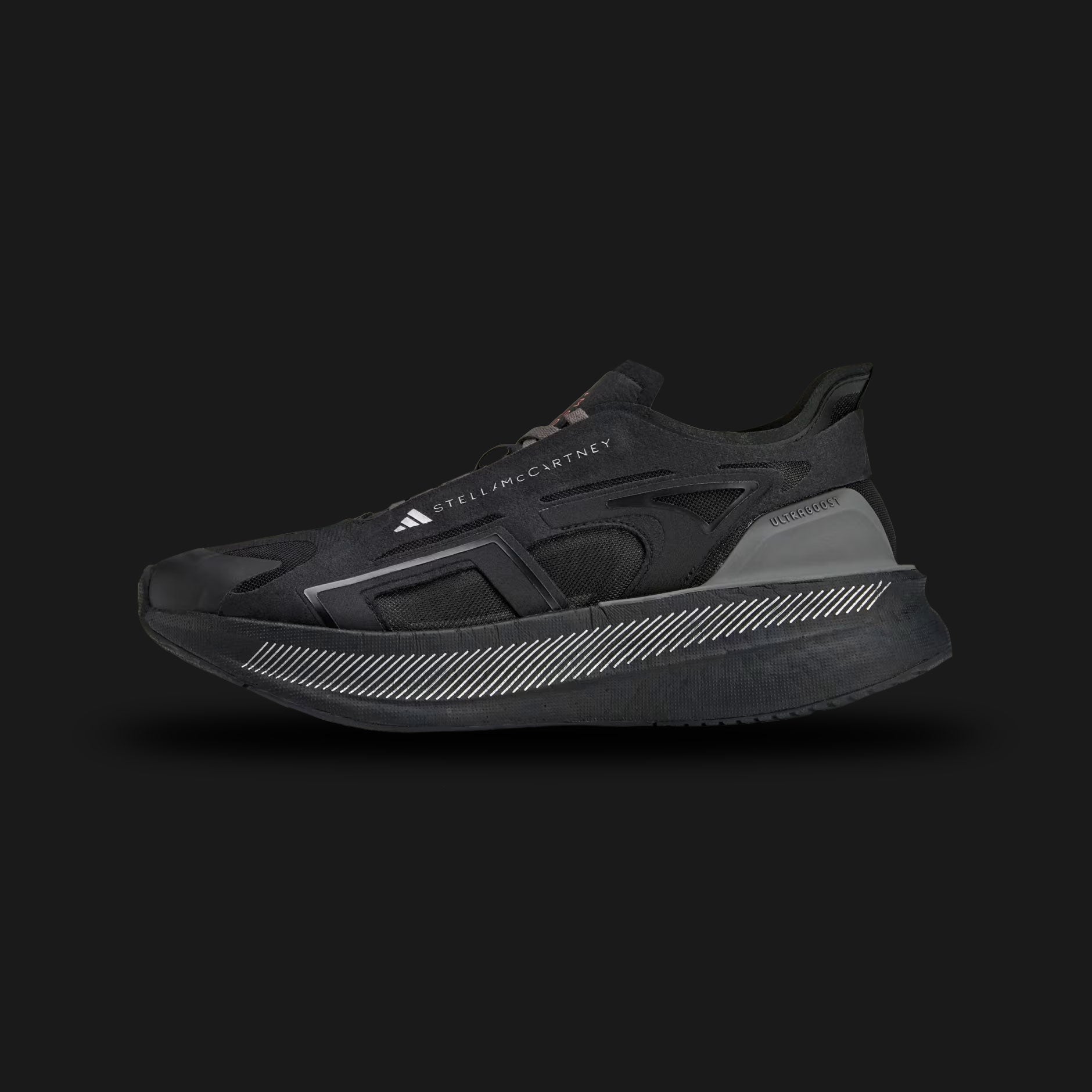 Adidas by Stella McCartney Ultraboost 5 shoes in Core Black, Crew Orange, and Charcoal (IE8771). Features a sustainable, breathable Core Black synthetic mesh upper encased in distinct Charcoal supportive overlays. Includes a thick, energy-returning Boost foam midsole, striking Crew Orange designer accents, and a durable rubber outsole. Luxuntique guarantees 100% authentic Adidas footwear in Sri Lanka.