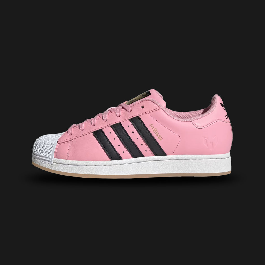 Adidas Superstar Messi shoes in Light Pink, Core Black, and Gold Metallic (JR1520). Features an Inter Miami inspired premium leather upper, iconic rubber shell toe, serrated Three-Stripes, and a durable rubber cupsole. Luxuntique guarantees 100% authentic footwear in Sri Lanka.