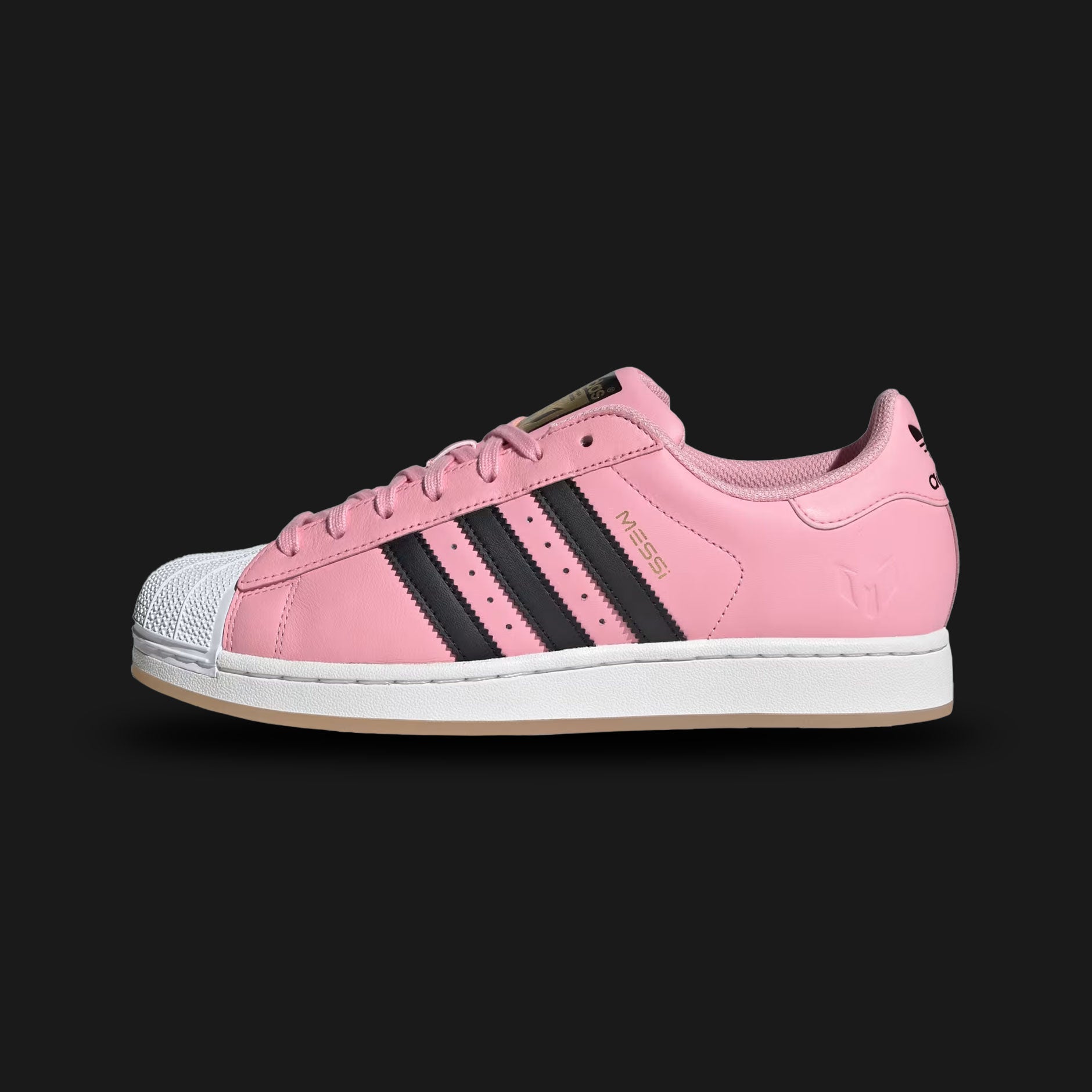 Adidas Superstar Messi shoes in Light Pink, Core Black, and Gold Metallic (JR1520). Features an Inter Miami inspired premium leather upper, iconic rubber shell toe, serrated Three-Stripes, and a durable rubber cupsole. Luxuntique guarantees 100% authentic footwear in Sri Lanka.