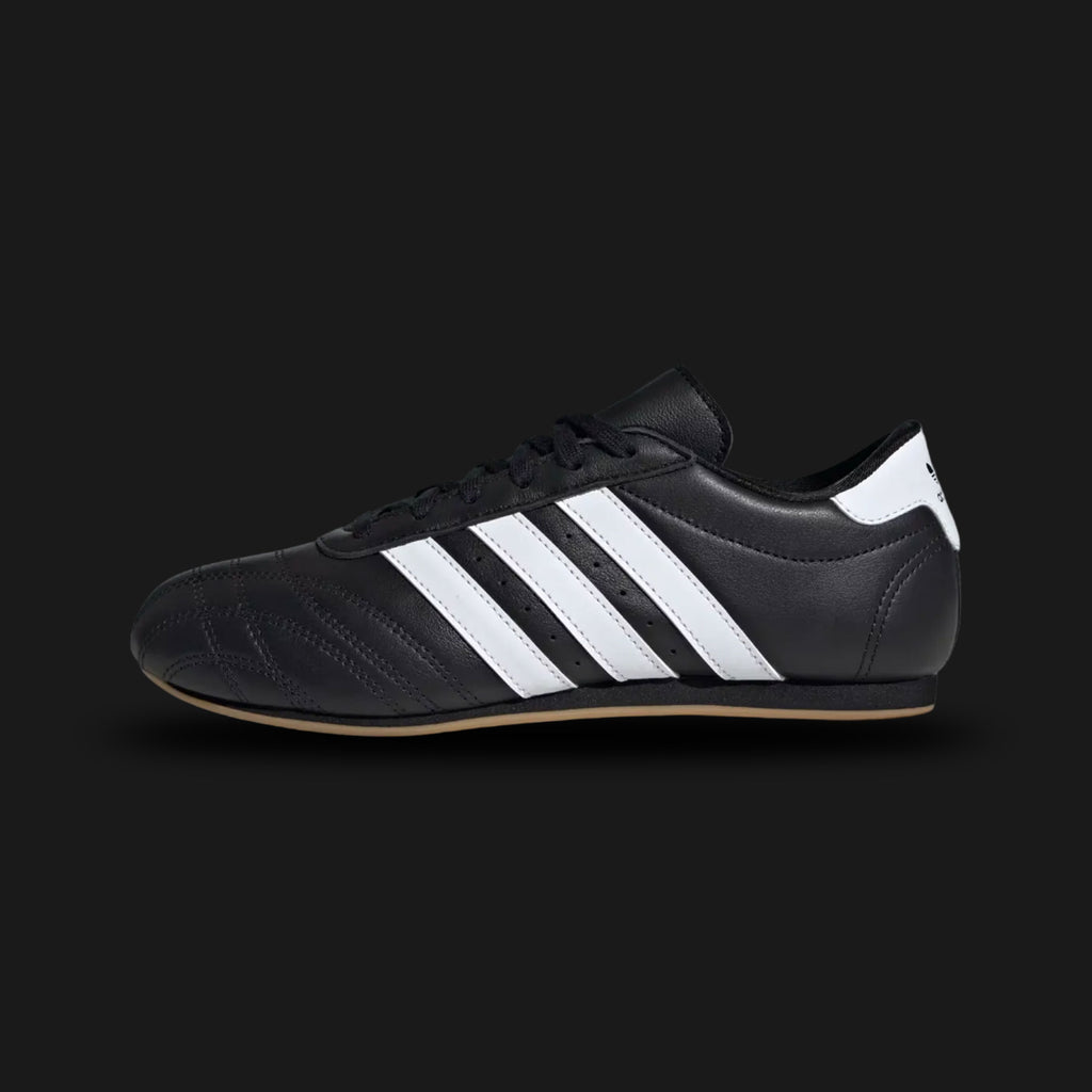 Adidas Taekwondo Lace shoes in Core Black, Cloud White, and Gum (JS1193). Features a premium soft black leather upper with traditional lacing, iconic white Three Stripes, and a thin, low-profile gum rubber outsole for a sleek, minimal martial-arts aesthetic. Luxuntique offers 100% authentic Adidas in Sri Lanka.