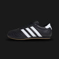 Adidas Taekwondo Lace shoes in Core Black, Cloud White, and Gum (JS1193). Features a premium soft black leather upper with traditional lacing, iconic white Three Stripes, and a thin, low-profile gum rubber outsole for a sleek, minimal martial-arts aesthetic. Luxuntique offers 100% authentic Adidas in Sri Lanka.