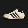 Adidas Taekwondo shoes in Cream White, Victory Blue, and Gum (JS4528). Features a premium soft leather slip-on upper in Cream White with iconic Victory Blue Three Stripes and a thin, low-profile gum rubber outsole. Designed for a sleek, minimal aesthetic. Luxuntique offers 100% authentic Adidas in Sri Lanka.