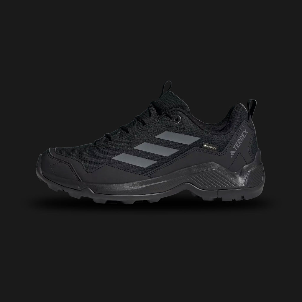 Adidas Terrex Eastrail GORE-TEX men's hiking shoes in Core Black and Grey Four (Design Code: ID7845). Featuring a waterproof, breathable GORE-TEX membrane to keep feet dry, a high-traction Traxion rubber outsole for superior grip on slippery terrain, and a lightweight EVA midsole. Luxuntique offers 100% authentic Adidas Terrex sneakers at the lowest price in Sri Lanka.