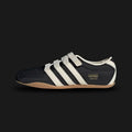 Adidas Tokyo MJ shoes in Core Black, Cream White, and Gold Metallic (JR4790). This Mary Jane-inspired sneaker features a premium black leather upper with a signature strap, cream white Three Stripes, and gold foil branding. Low-profile heritage design with a slim rubber sole. Luxuntique offers 100% authentic Adidas in Sri Lanka.