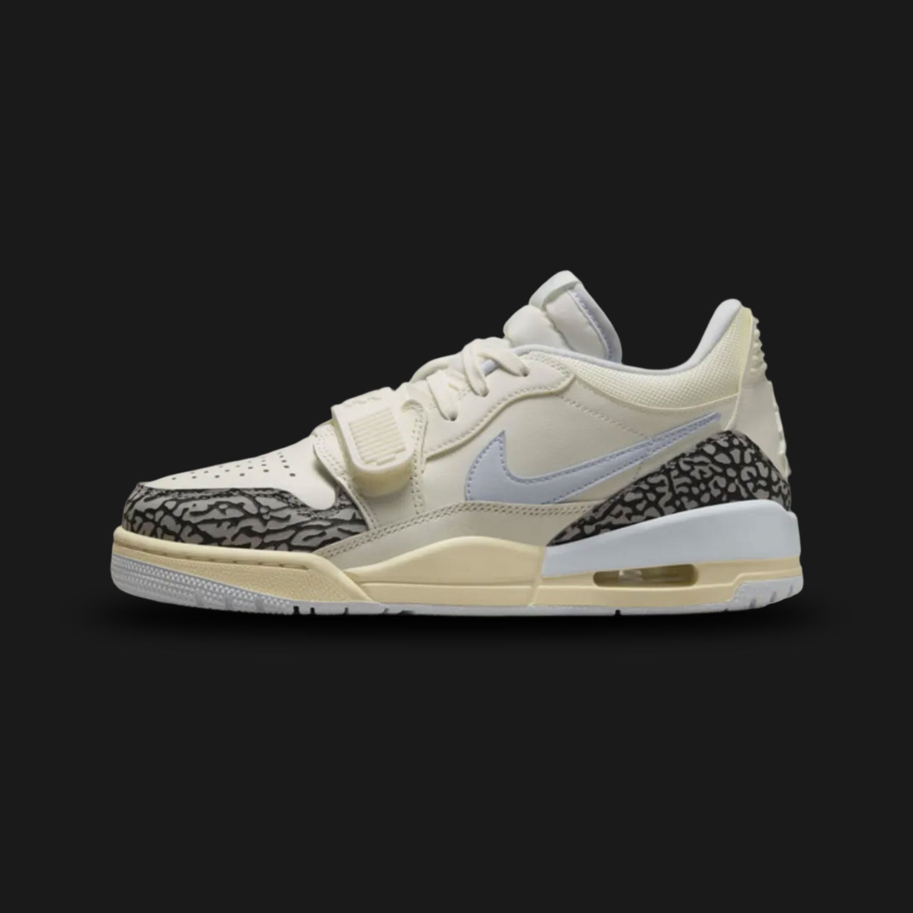 Air Jordan Legacy 312 Low lifestyle sneakers in Sail, Cement Grey, Black, and Football Grey (Design Code: FQ7827-101). Featuring a premium layered leather upper combining a crisp Sail base with cool Football Grey accents and iconic Cement Grey detailing. Defined by a bold Black adjustable midfoot lockdown strap, classic Nike Swoosh, and signature hybrid Jordan design elements. Anchored by a vintage-inspired foam midsole housing a visible Air Max unit in the heel, all resting on a durable rubber outsole. Lux