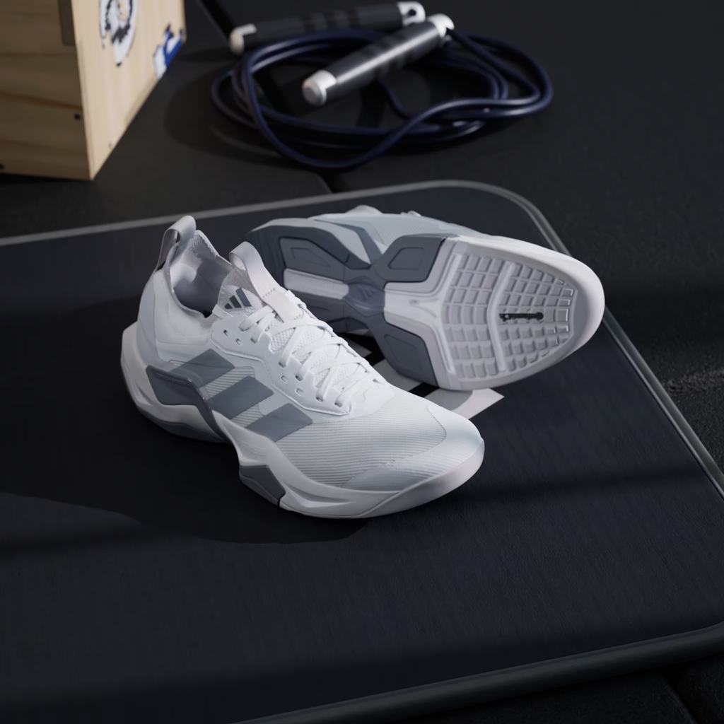 Adidas Rapidmove ADV 2 JI4196 - Front 3/4 Pair Shot on Gym Floor showing Cloud White Mesh Upper, Halo Silver Three Stripes, Grey Structural Overlays, Torsion System Text, Lightstrike Pro Midsole & Outsole Visible