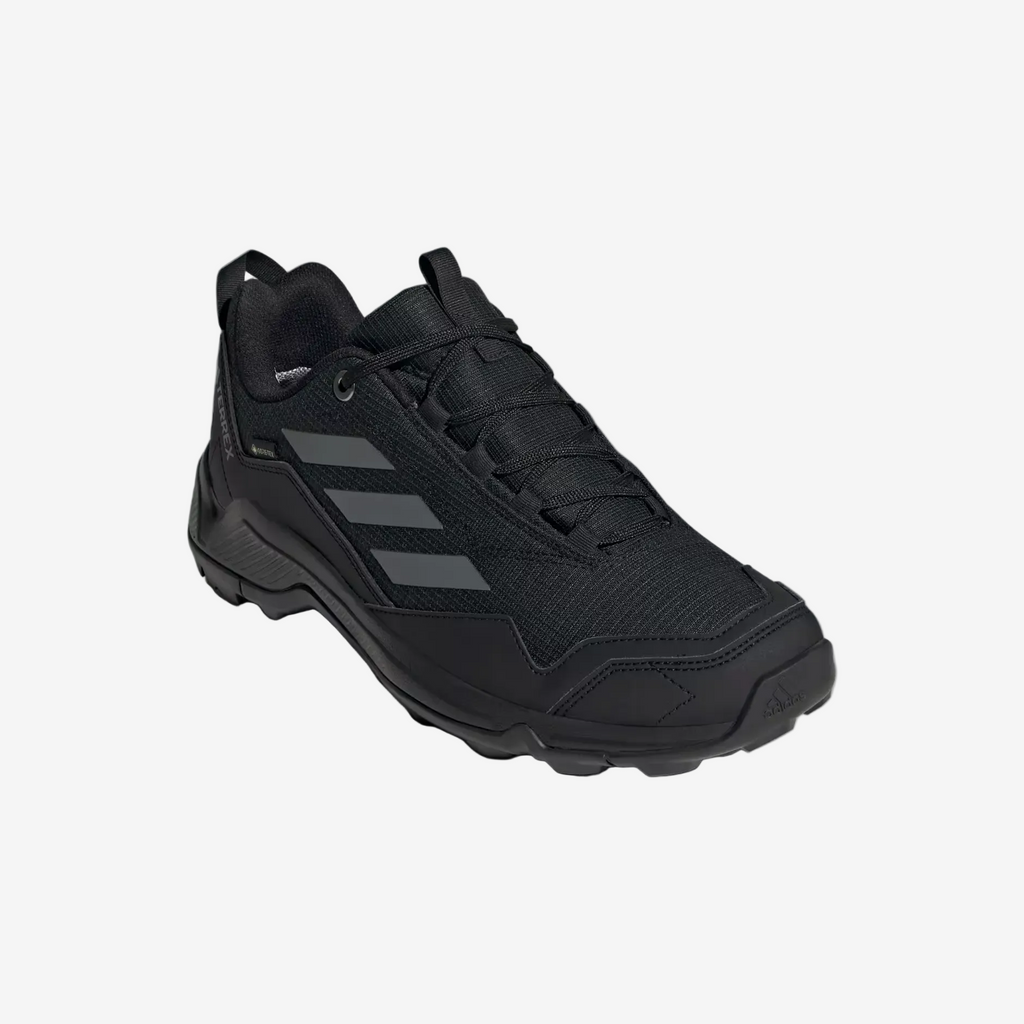 Black Adidas sneaker on a light gray background