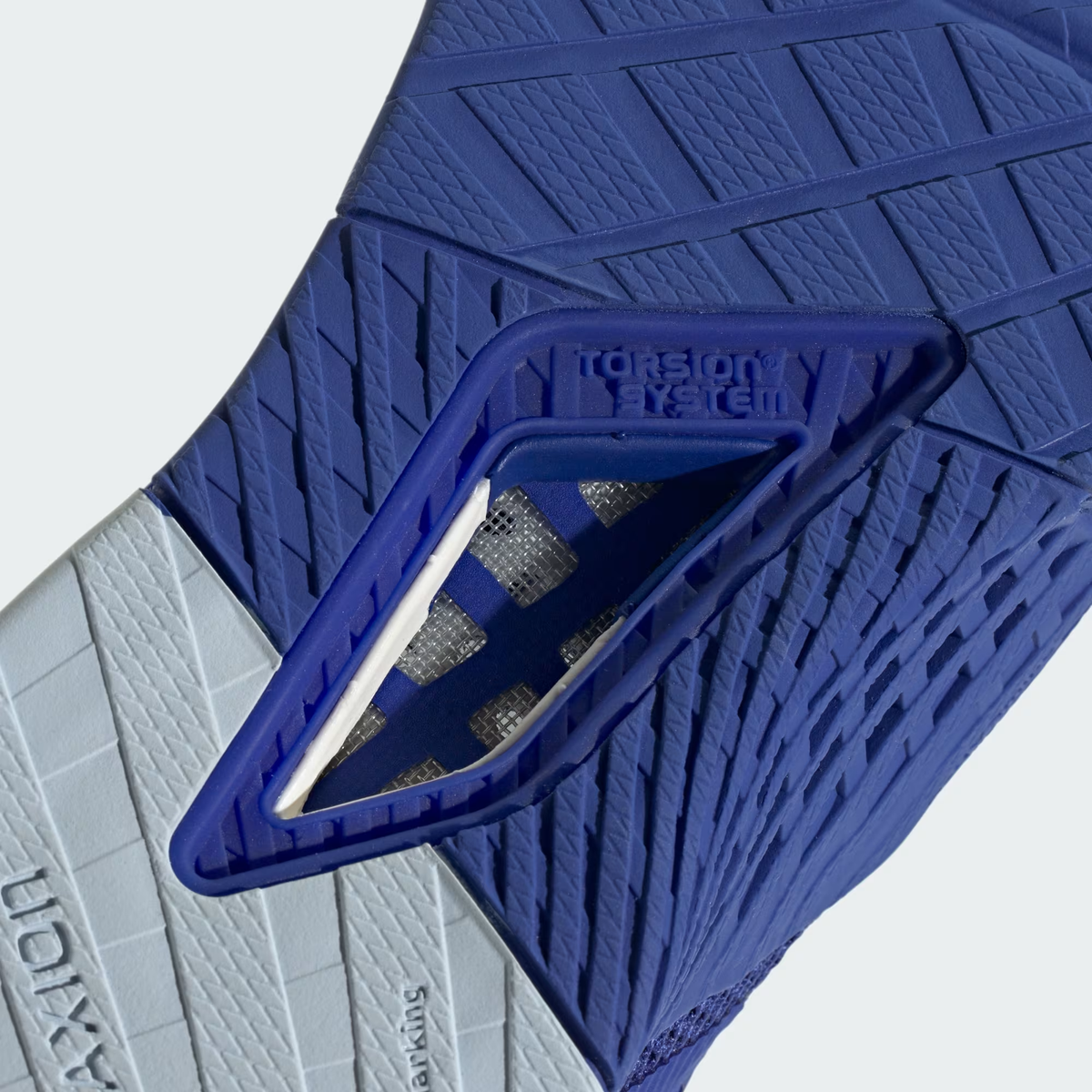 Adidas Dropset 3 ID8636 - Gym Lifestyle On-Foot Shot showing athlete lacing up Lucid Blue Dropset 3 on gym bench, White Cloud Three Stripes on Lateral Midfoot, Dual Density Midsole Text, Adiware Heel Cage & Blue Rubber Outsole in training environment
