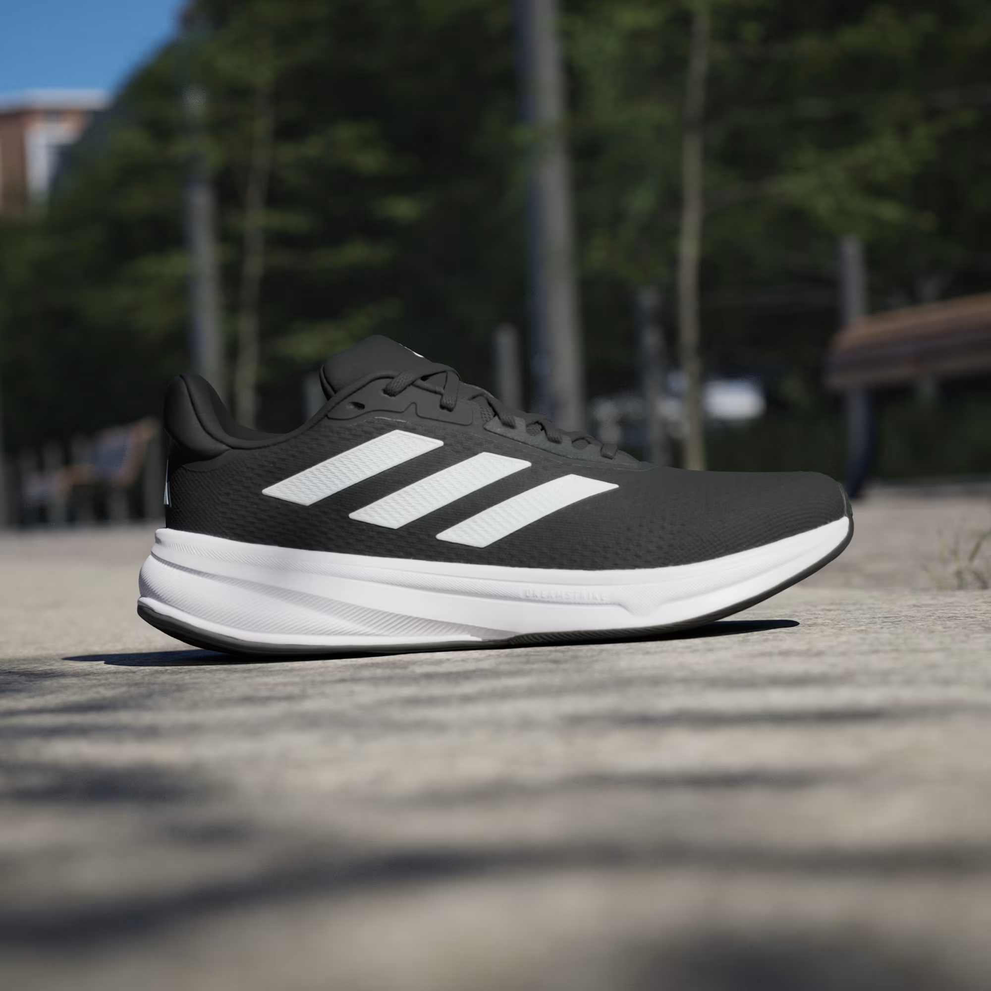 Adidas Response Super JI4308 - Front 3/4 Pair Shot on Cobblestone in Core Black/Cloud White showing Engineered Mesh Upper, Bold White Three Stripes & Chunky White Response Midsole