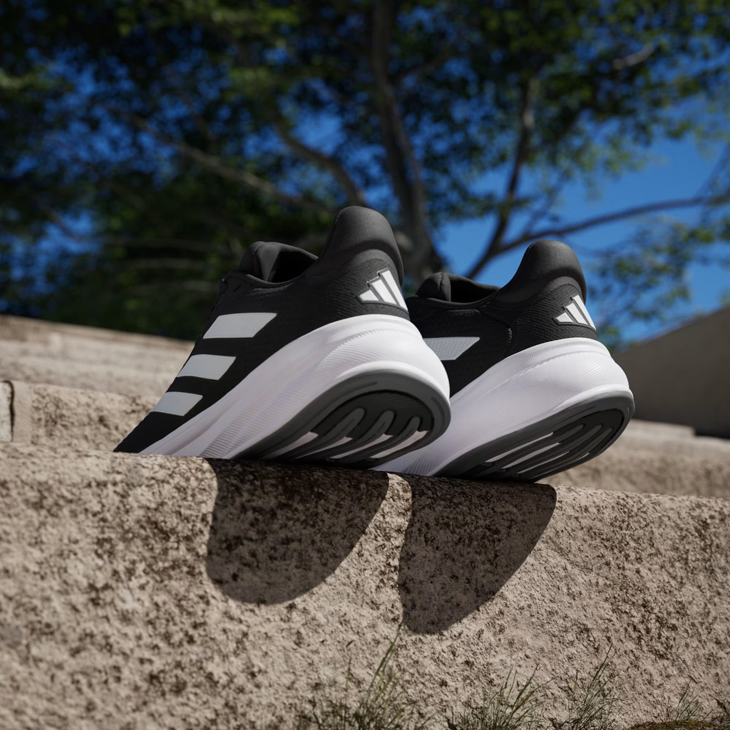 Adidas Response Super JI4308 - Front 3/4 Pair Shot on Concrete Bench in Core Black/Cloud White showing Response Super Branding, White Three Stripes & White Midsole
