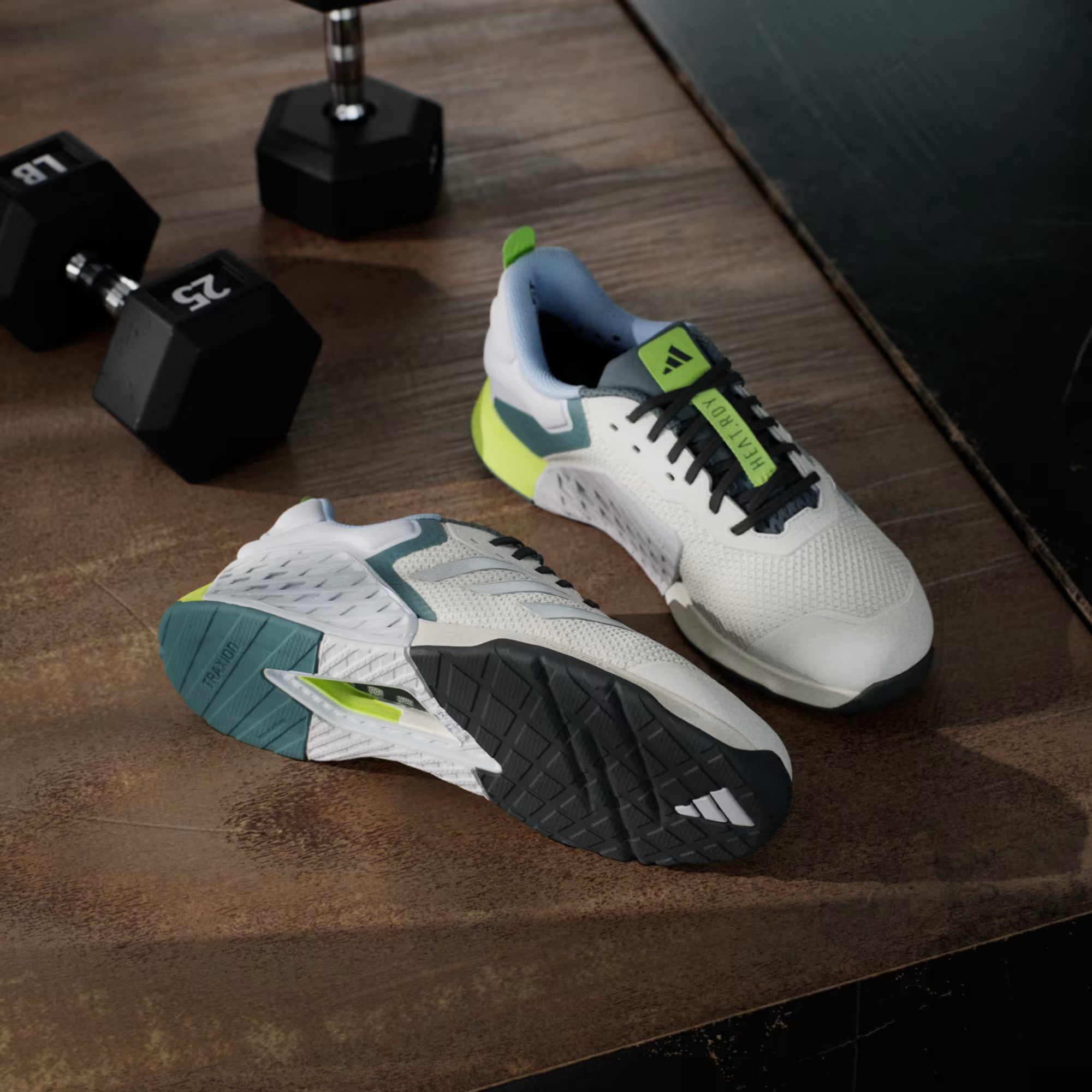 Adidas Dropset 3 JR1762 - Rear 3/4 Pair Shot on Metal Gym Platform showing Chalk White Upper, Silver Three Stripes on Lateral, Teal Heel Counter, Neon Yellow Heel Pull Tab with Adidas Badge & Dual Density Midsole