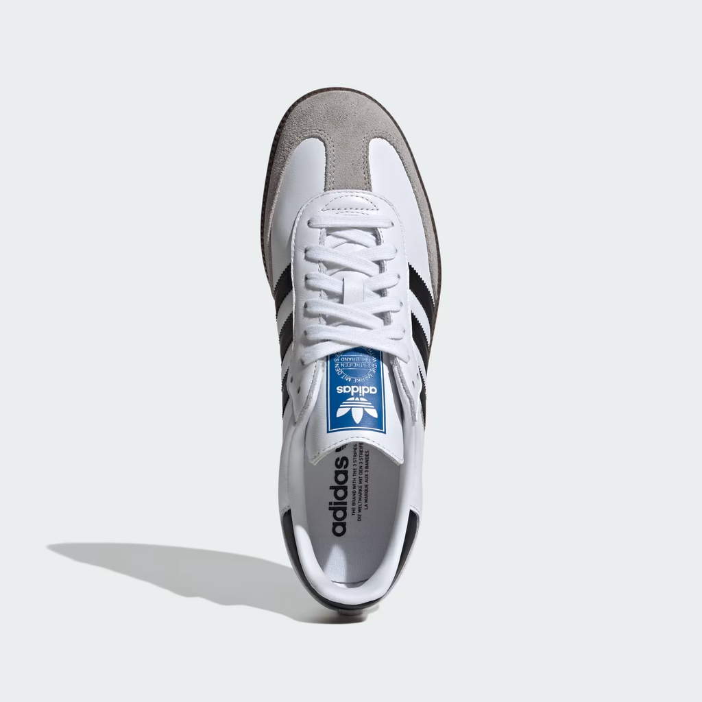 Adidas Samba OG B75806 - Rear 3/4 Pair Shot on Light Grey Background in Cloud White/Core Black/Clear Granite showing White Full-Grain Leather Upper, Gold Samba Wordmark on Lateral Quarter Panel, Core Black Three Stripes, Core Black Heel Counter, Blue Adidas Trefoil Tongue Badge & Gum Rubber Outsole