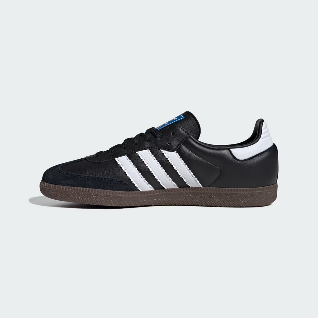 Adidas Samba OG B75807 - Toe Box & Forefoot Top-Down Close-up showing Black Suede Toe Cap Texture, Core Black Full-Grain Leather Upper, Black Flat Laces, Cloud White Three Stripes Base, Blue Adidas Originals Tongue Label with Trefoil Logo & Gum Rubber Outsole Edge