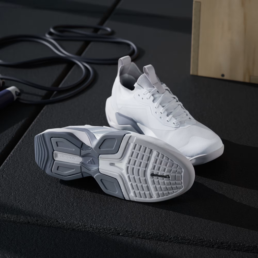 Adidas Rapidmove ADV 2 JI4196 - Rear 3/4 Pair Shot on Wooden Gym Box showing Cloud White Upper, Halo Silver Three Stripes, Torsion System Text, Lightstrike Pro Midsole Branding & Grey Rubber Outsole