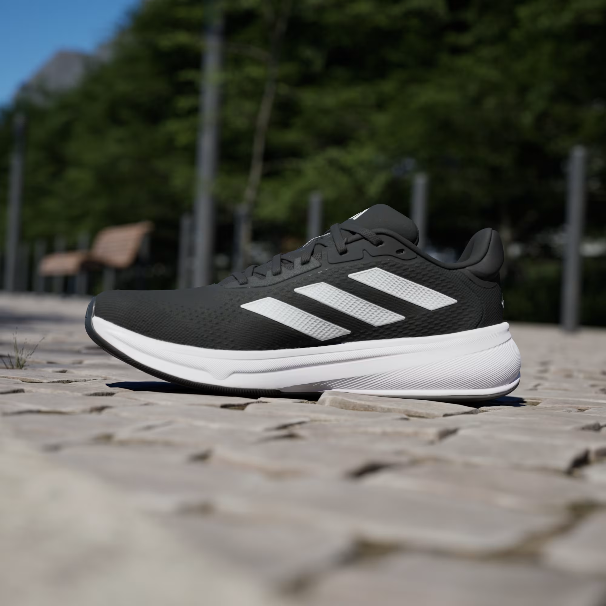 Adidas Response Super JI4308 - Low-Angle Forefoot Pair Shot on Cobblestone showing Black Engineered Mesh Texture, Bold White Three Stripes & White Response Midsole