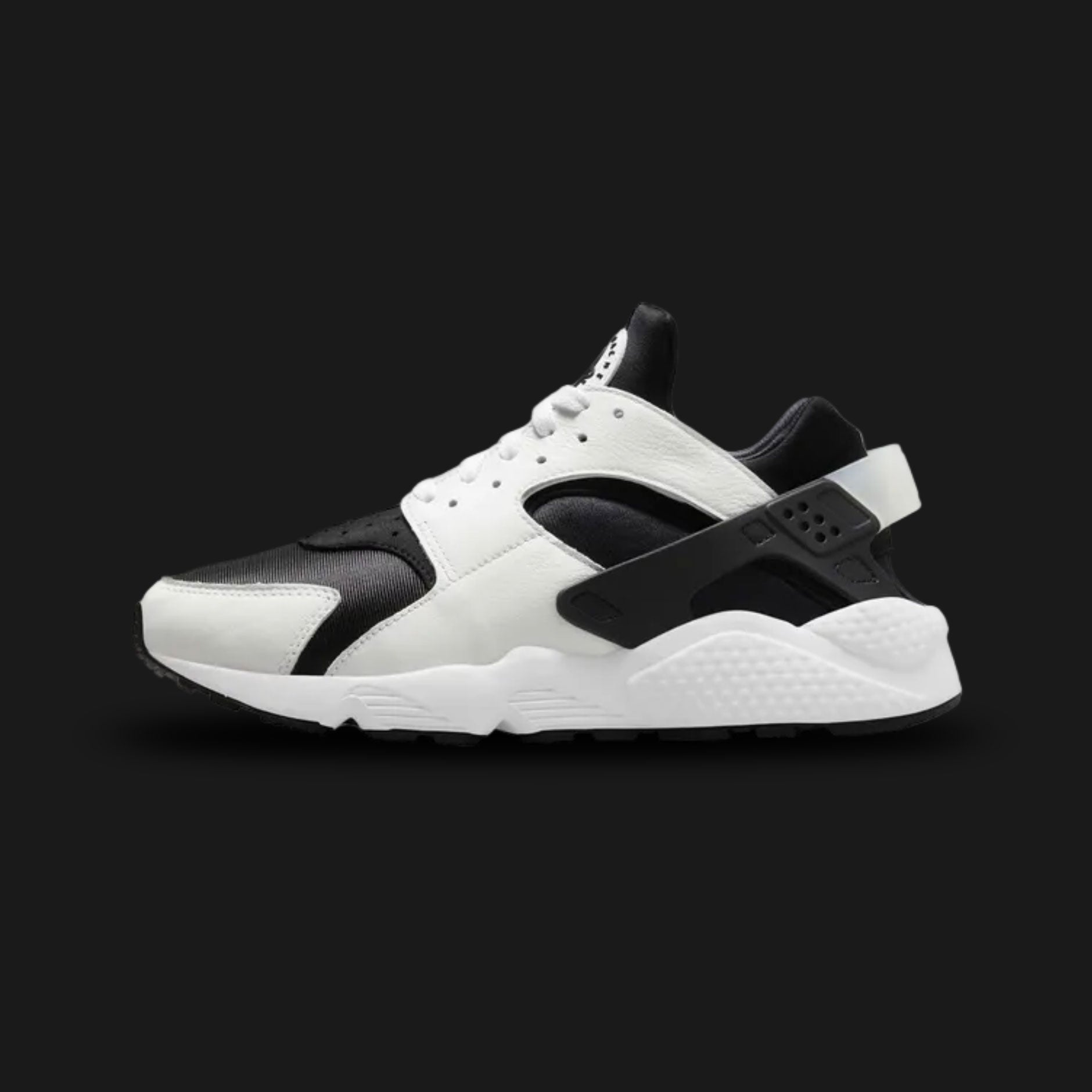 Nike Air Huarache lifestyle running shoes in Black and White (Design Code: DD1068-001). Featuring a signature foot-hugging black neoprene inner sleeve surrounded by durable black leather and textile overlays for a custom fit. Defined by its iconic black plastic heel clip and stripped-away branding, all resting on a plush, contrasting crisp white foam midsole with encapsulated Nike Air cushioning. Luxuntique offers 100% authentic Nike retro sneakers at the lowest price in Sri Lanka.
