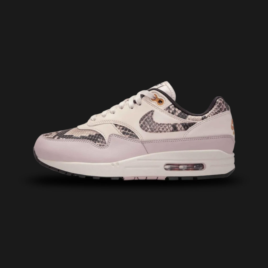 Nike Air Max 1 '87 premium lifestyle sneakers in Light Orewood Brown, Malt, Velvet Brown, and Multi-Colour (Design Code: HF5338-100). Featuring a richly textured upper that blends breathable Light Orewood Brown mesh with premium Malt suede overlays. Anchored by a bold, dark Velvet Brown suede mudguard and accented with Multi-Colour detailing. Supported by a classic white foam midsole housing the iconic, visible Air Max heel unit. Luxuntique offers 100% authentic Nike retro footwear at the lowest price in Sr