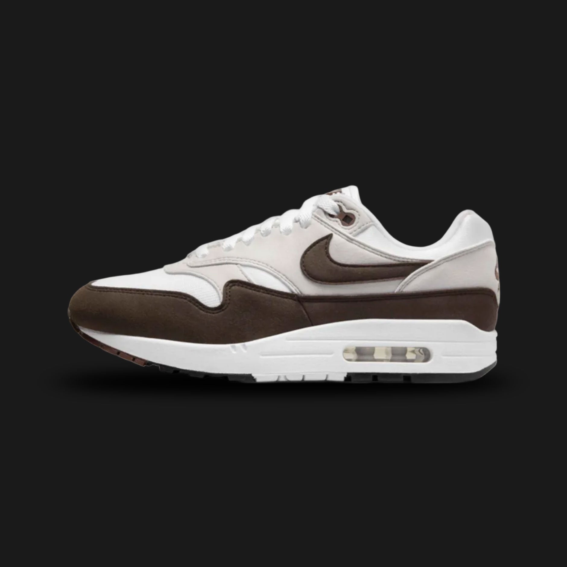 Nike Air Max 1 sneakers in Baroque Brown, Neutral Grey, White, and Black (DZ2628-004). Featuring a rich Baroque Brown suede mudguard and Swoosh over a Neutral Grey and White mesh upper. Anchored by a crisp White midsole with visible Air cushioning and a tri-color outsole. Luxuntique offers 100% authentic Nike footwear in Sri Lanka.