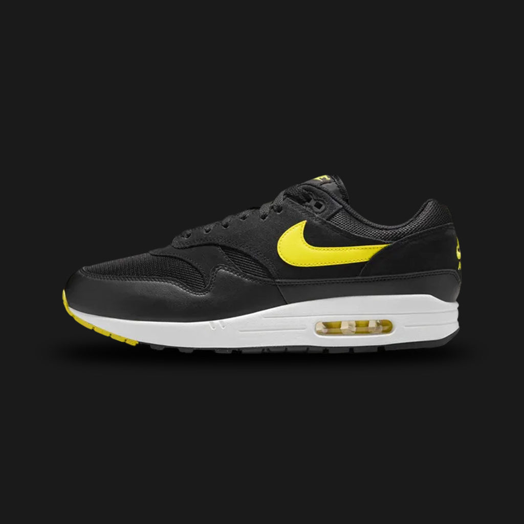 Nike Air Max 1 Essential shoes in Black, Summit White, and Opti Yellow (Design Code: FZ5808-005). Featuring a mixed-material upper of breathable mesh and durable synthetic overlays in Black, contrasted by a crisp Summit White Swoosh and energetic Opti Yellow branding. Built on a foam midsole with the iconic visible Max Air unit in the heel for all-day comfort. Luxuntique offers 100% authentic Nike Air Max sneakers at the lowest price in Sri Lanka.