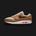 Nike Air Max 1 Essential shoes in Light Bone, Flax, British Tan, and Black (Design Code: FZ5808-004). Featuring a premium mixed-material upper with a breathable Light Bone mesh base and rich British Tan suede mudguards. Accented with warm Flax overlays and a sharp Black Swoosh for a sophisticated earth-tone look. Built on a foam midsole with the iconic visible Max Air unit in the heel. Luxuntique offers 100% authentic Nike Air Max sneakers at the lowest price in Sri Lanka.