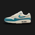 Nike Air Max 1 Essential shoes in Soft Pearl, Light Khaki, Black, and Smoky Blue (Design Code: FZ5808-011). Featuring a breathable Soft Pearl mesh upper with Light Khaki overlays and a sharp Black mudguard for contrast. Accented with cool Smoky Blue details on the Swoosh and branding. Built on a foam midsole with the iconic visible Max Air unit in the heel for all-day comfort. Luxuntique offers 100% authentic Nike Air Max sneakers at the lowest price in Sri Lanka.