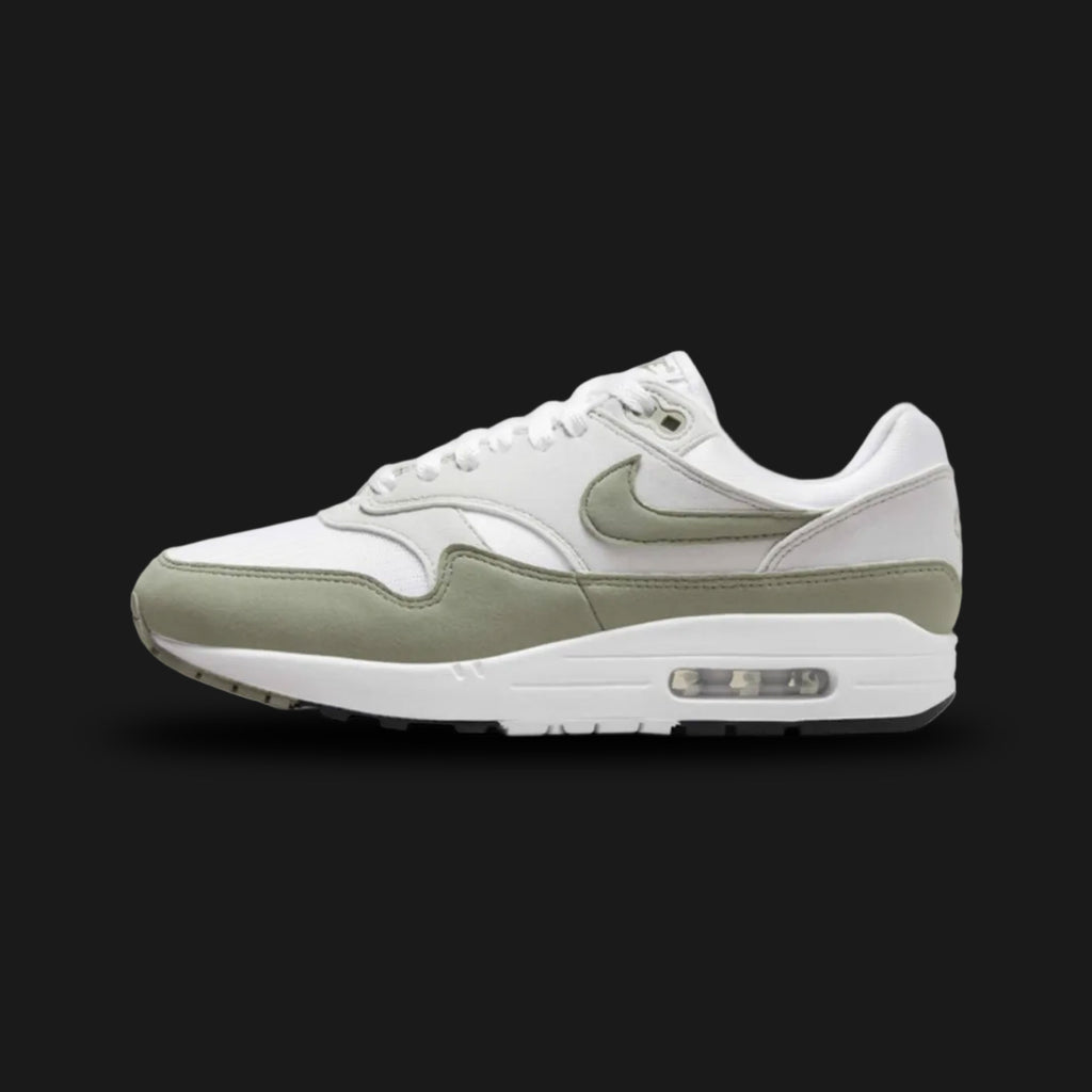 Nike Air Max 1 sneakers in Light Army, Neutral Grey, White, and Black (DZ2628-112). Features a muted Light Army green suede mudguard and Swoosh over Neutral Grey and White mesh. Anchored by a crisp White midsole with visible Air cushioning and a Black rubber outsole. Luxuntique offers 100% authentic Nike footwear in Sri Lanka.