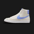 Nike Blazer Mid '77 women's shoes in Phantom, White, and Royal Pulse blue (Design Code: CZ1055-004). Featuring an off-white Phantom leather upper with vibrant Royal Pulse blue Swoosh and heel branding. Includes the signature exposed foam tongue and a crisp white vulcanized rubber outsole for a classic heritage look. Luxuntique offers 100% authentic Nike Blazer sneakers at the lowest price in Sri Lanka.