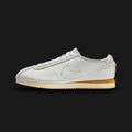 Nike Cortez Leather in White, Light Bone, and Coconut Milk (HQ1841-100). Features a premium white leather upper with Light Bone overlays and a metallic Bronze Swoosh. Iconic serrated sole and wedge midsole finished in aged Coconut Milk. Luxuntique offers 100% authentic Nike footwear in Sri Lanka.