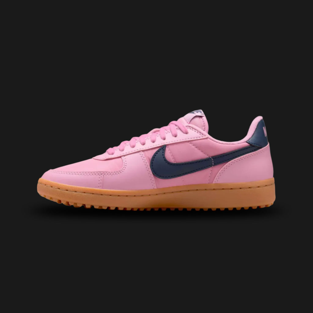 Nike Field General '82 vintage lifestyle shoes in Elemental Pink, Gum Medium Brown, and Obsidian (Design Code: FZ5593-600). Featuring a breathable, vibrant Elemental Pink nylon upper reinforced with matching tonal suede overlays for a classic 1980s turf aesthetic. Accented by a bold, high-contrast Obsidian navy blue leather Nike Swoosh and heel tab. Securely built on a rugged, Gum Medium Brown rubber waffle outsole originally designed for gridiron traction. Luxuntique offers 100% authentic Nike retro footwe