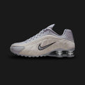 Nike Shox R4 sneakers in Cement Grey, College Grey, and Metallic Silver (HQ7739-001). Sleek synthetic leather upper featuring Metallic Silver hits and signature four-pillar Shox heel cushioning in Black. Luxuntique offers 100% authentic Nike footwear in Sri Lanka.