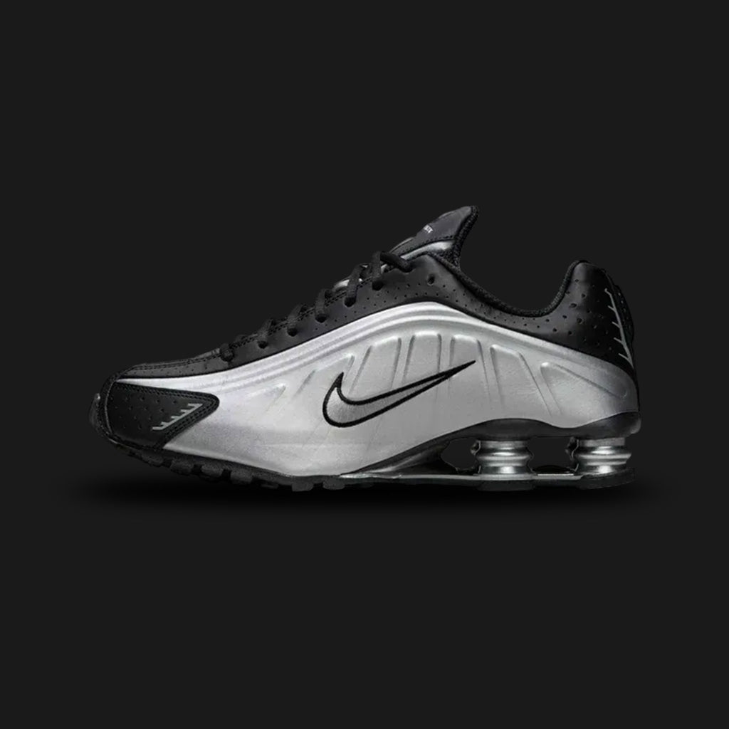 Nike Shox R4 shoes in Metallic Silver and Black (Design Code: HQ1988-007). Featuring a futuristic, seamless synthetic upper in gleaming Metallic Silver with breathable perforations and bold black detailing. Supported by the iconic 4-column Nike Shox cushioning system in the heel for responsive impact protection and a distinct Y2K aesthetic. Luxuntique offers 100% authentic Nike Shox sneakers at the lowest price in Sri Lanka.