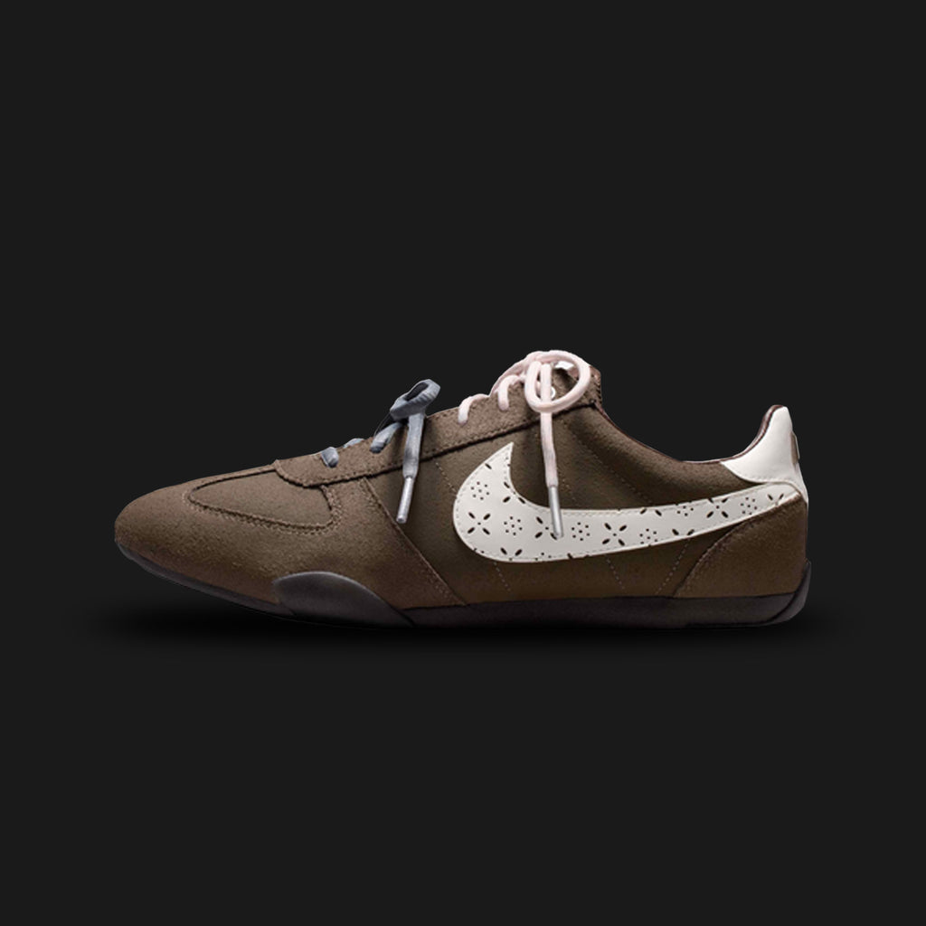 Nike Sprint Sister shoes in Ridgerock, Ocean Cube, Dark Cinder, and Sail (IR5693-256). Features a sleek, low-profile retro track silhouette with a breathable mesh and synthetic suede upper in deep earthy browns. Includes striking Ocean Cube teal accents, a slim Sail midsole for lightweight cushioning, and a grippy rubber waffle outsole. Luxuntique offers 100% authentic Nike in Sri Lanka.
