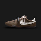 Nike Sprint Sister shoes in Ridgerock, Ocean Cube, Dark Cinder, and Sail (IR5693-256). Features a sleek, low-profile retro track silhouette with a breathable mesh and synthetic suede upper in deep earthy browns. Includes striking Ocean Cube teal accents, a slim Sail midsole for lightweight cushioning, and a grippy rubber waffle outsole. Luxuntique offers 100% authentic Nike in Sri Lanka.