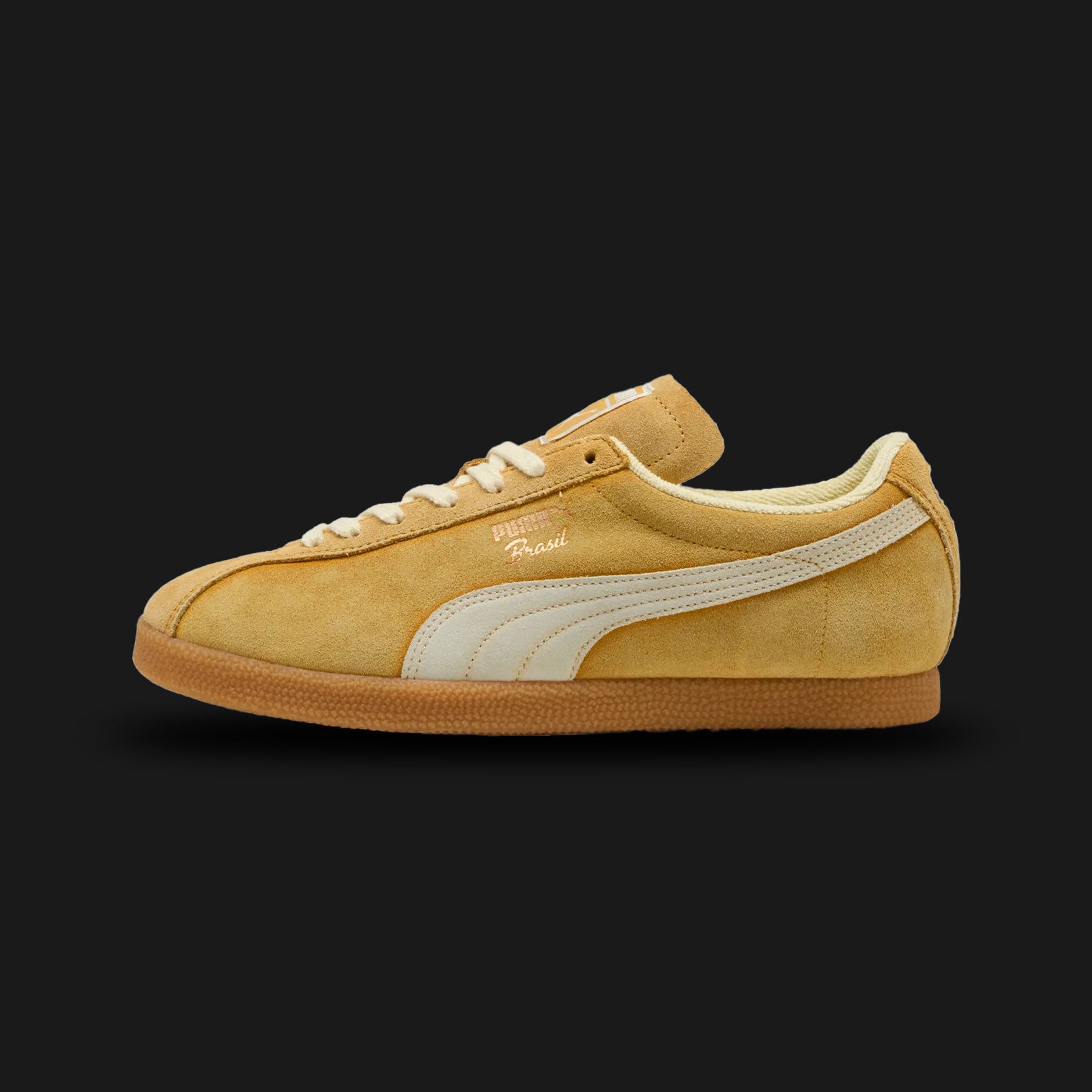 Puma Brasil The NeverWorn V unisex sneakers in Archive Gold and Creamy Vanilla (401643_01). Features a retro football-inspired silhouette reimagined with an authentic vintage aesthetic, showcasing a premium Archive Gold hairy suede upper and a contrasting Creamy Vanilla formstrip. Includes weathered/aged design detailing on the midsole, classic gold-foil branding, and a durable flat rubber outsole. Luxuntique guarantees 100% authentic Puma footwear in Sri Lanka.