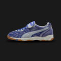 Puma x KidSuper King Indoor unisex sneakers in Dart Blue and Gray Fog (401180_01). Features a collaborative, art-inspired design reimagining the classic King silhouette with vibrant color-blocking and signature KidSuper aesthetic details. Constructed with a premium upper for comfort, co-branded detailing, and a flat rubber outsole for optimal indoor performance and high-fashion street style. Luxuntique guarantees 100% authentic Puma footwear in Sri Lanka.