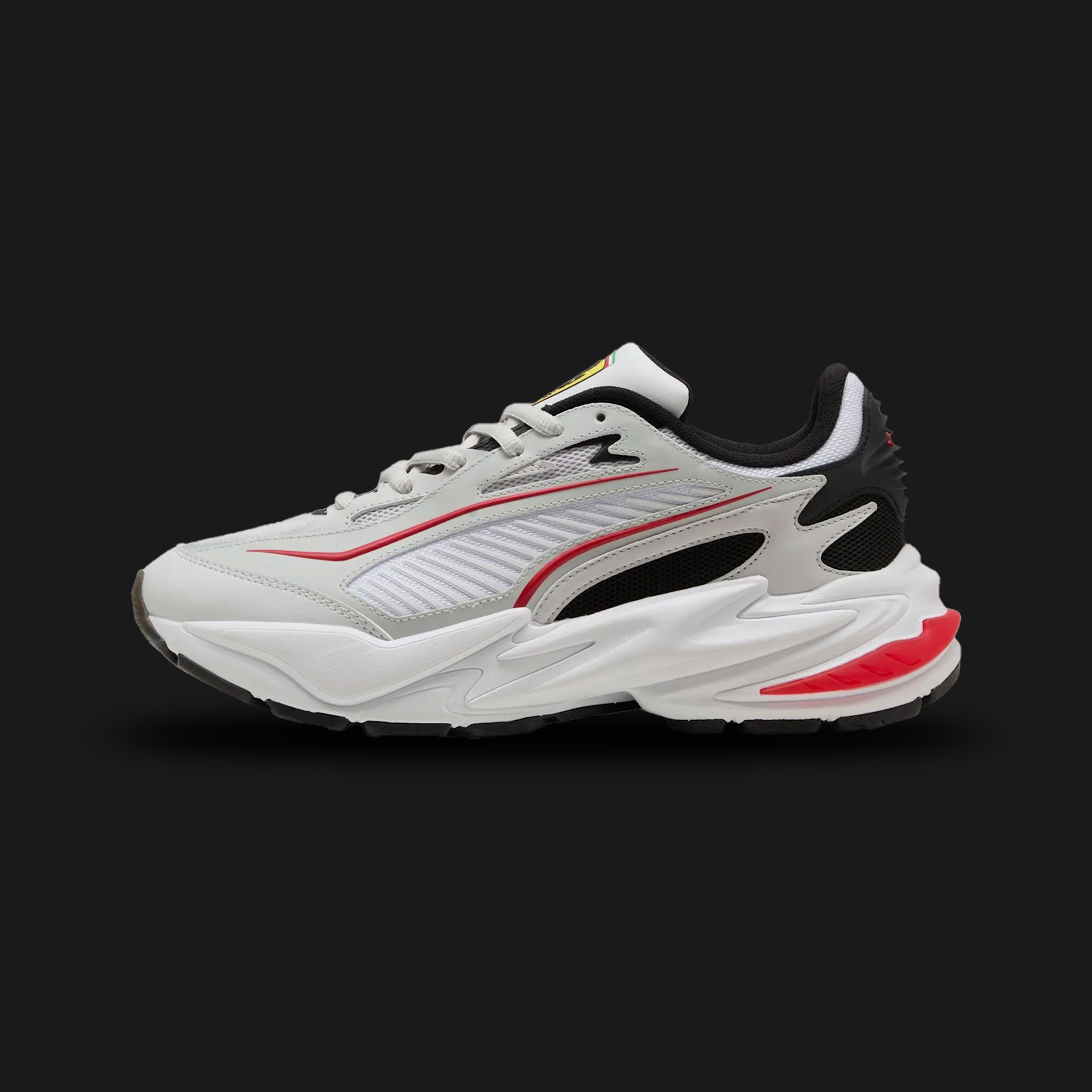 Puma Scuderia Ferrari RS Surge unisex sneakers in Feather Gray and Puma White (309127_01). Features a chunky motorsport-inspired silhouette with a breathable Feather Gray mesh and synthetic upper. Includes the iconic Scuderia Ferrari shield branding, classic Puma White accents, and a bulky RS (Running System) foam midsole for supreme everyday cushioning and street-ready style. Luxuntique guarantees 100% authentic Puma footwear in Sri Lanka.