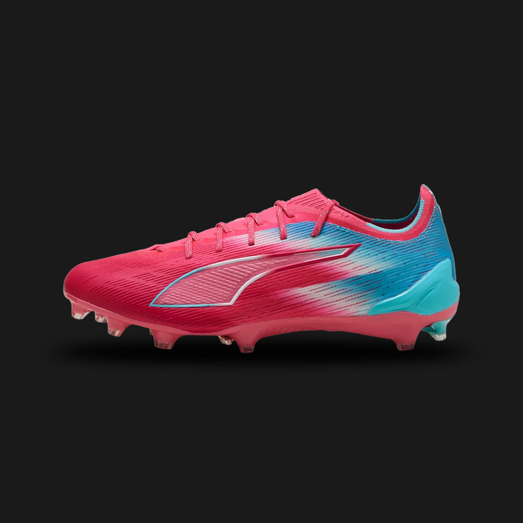 Puma Ultra 6 Ultimate Re-Charge FG unisex football boots in Hero Blue, Sunset Pink, and Garnet Rose (108763_01). Features an engineered mesh upper with a PWRTAPE support frame for stability without hindering agility. Includes vibrant Sunset Pink accents and a SPEEDSYSTEM outsole with FastTrax stud design for lightning-fast acceleration and multidirectional traction on Firm Ground. Luxuntique guarantees 100% authentic Puma footwear in Sri Lanka.