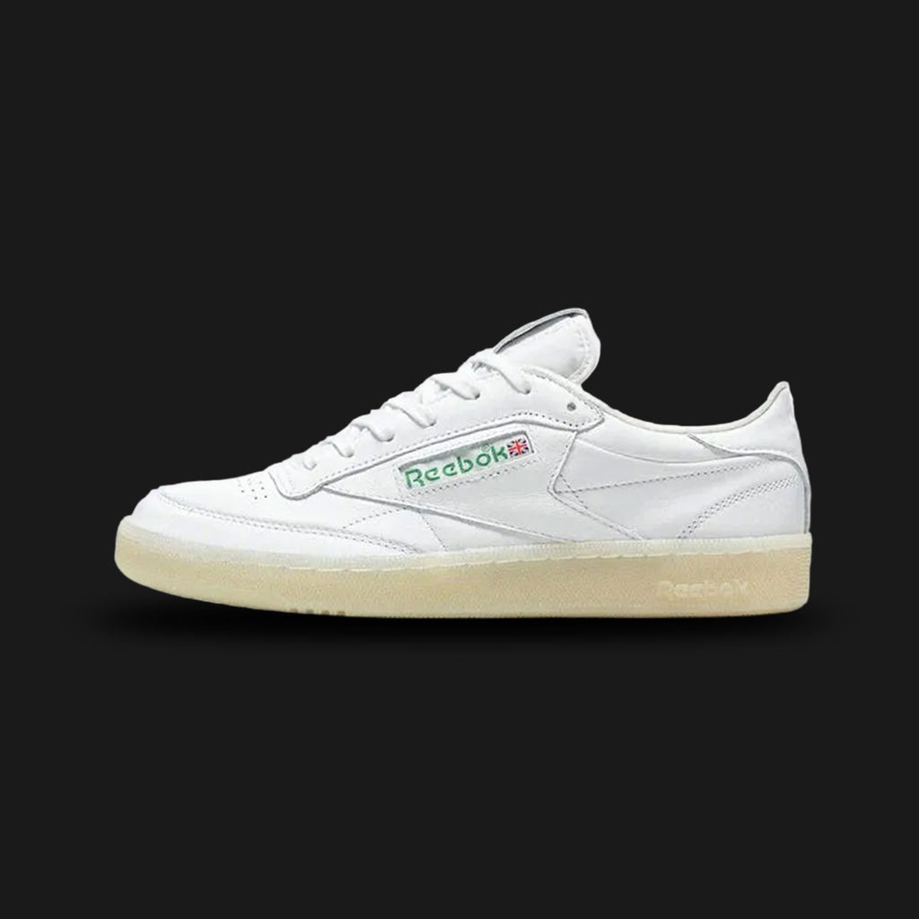 Reebok Club C 85 Vintage shoes in Chalk, Paper White, and Glen Green (Design Code: 100209029). Featuring a premium garment leather upper with an aged vintage aesthetic, soft terry cloth lining, and the iconic Union Jack logo window. Includes a comfortable EVA midsole and a durable rubber outsole. Luxuntique offers 100% authentic Reebok heritage sneakers at the lowest price in Sri Lanka.