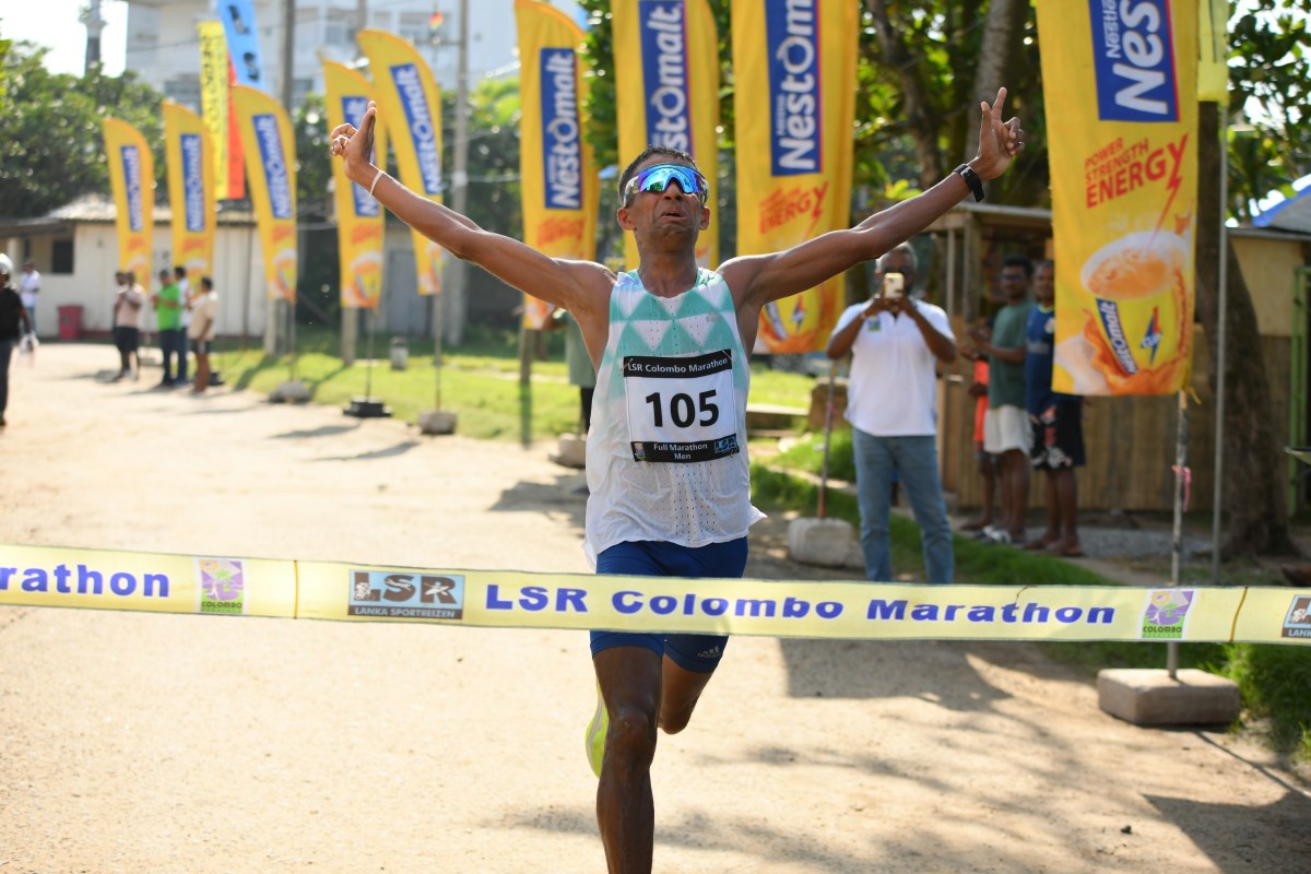 Udara Chanaka Rupasinghe, bib 105, crossing the finish line of the LSR Colombo Marathon 2026 with both arms raised
