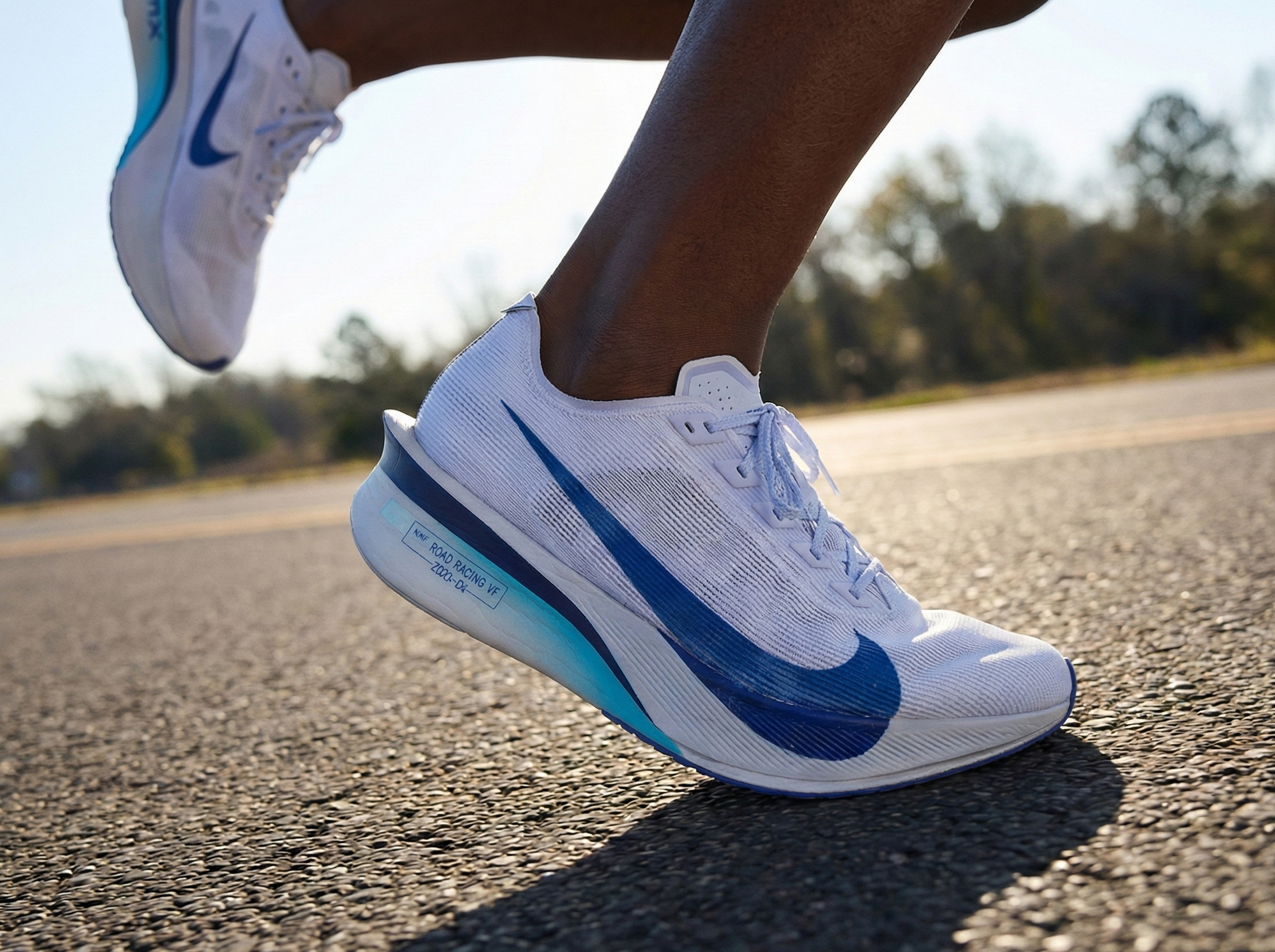 White and blue running shoes on a road with blurred trees in the background Sri Lanka